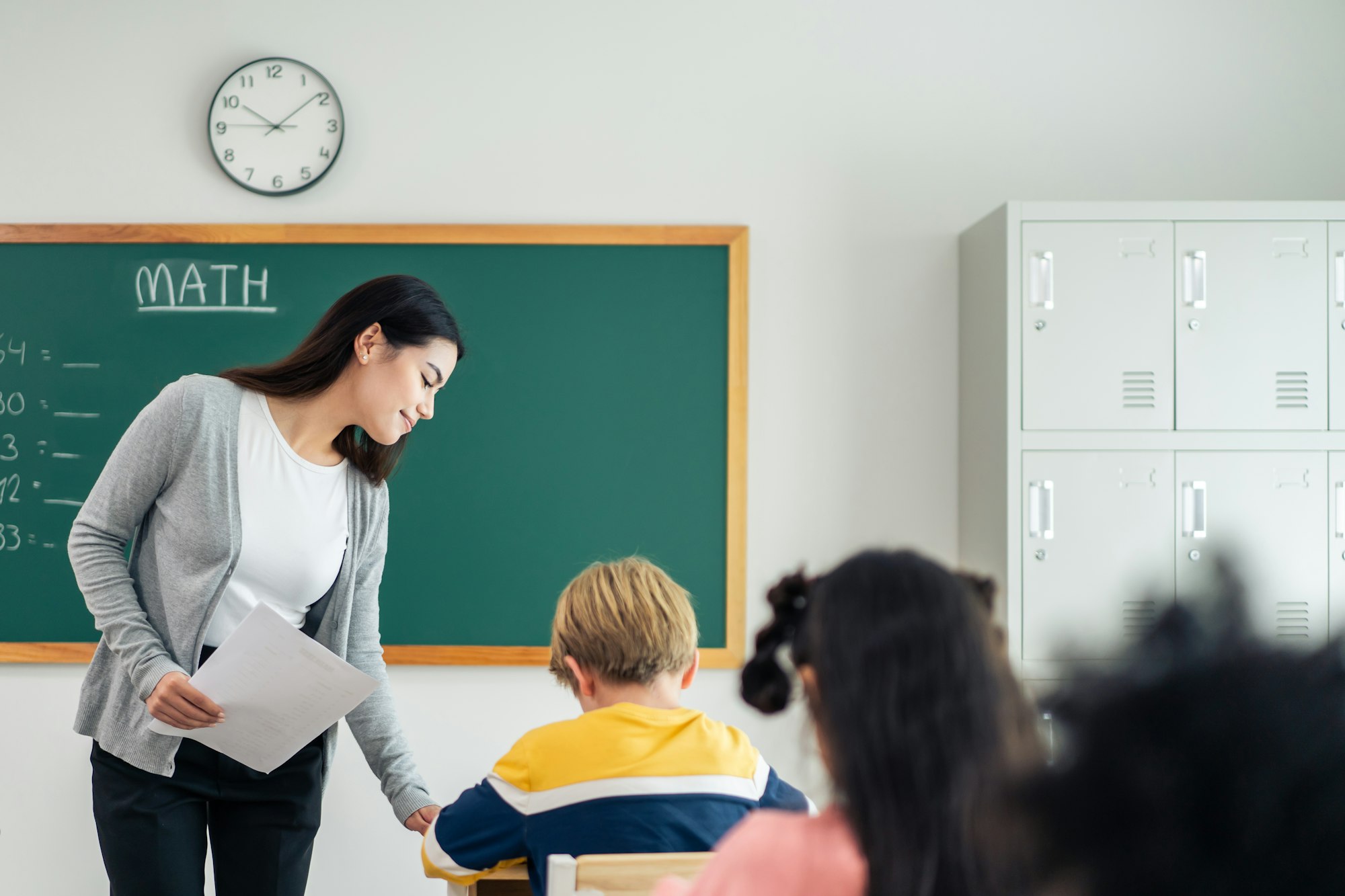 Group of student learn with teacher in classroom at elementary school.